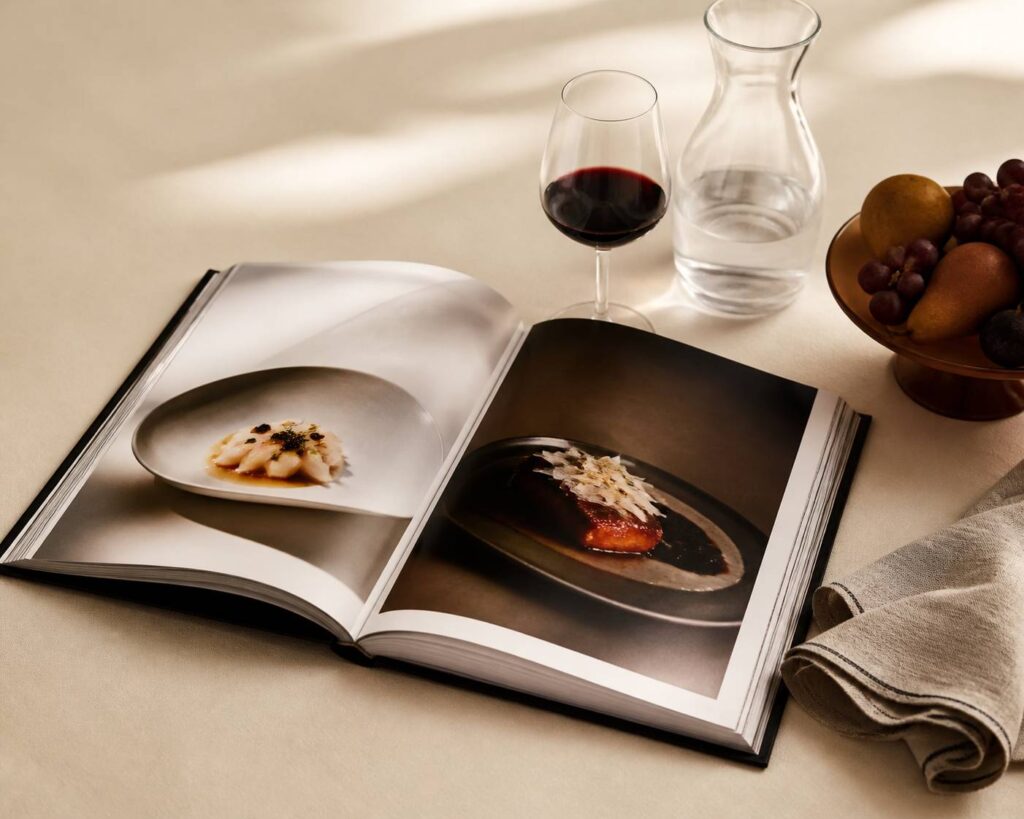 Table éditoriale avec magazine gastronomique et verre de vin